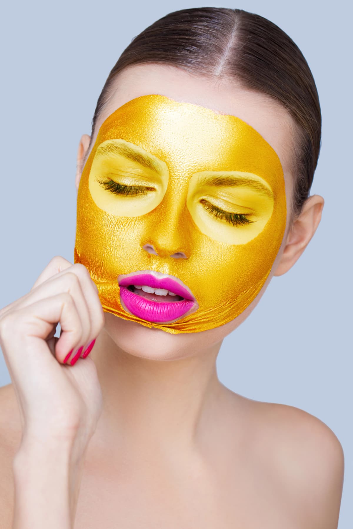 Woman applying golden mask